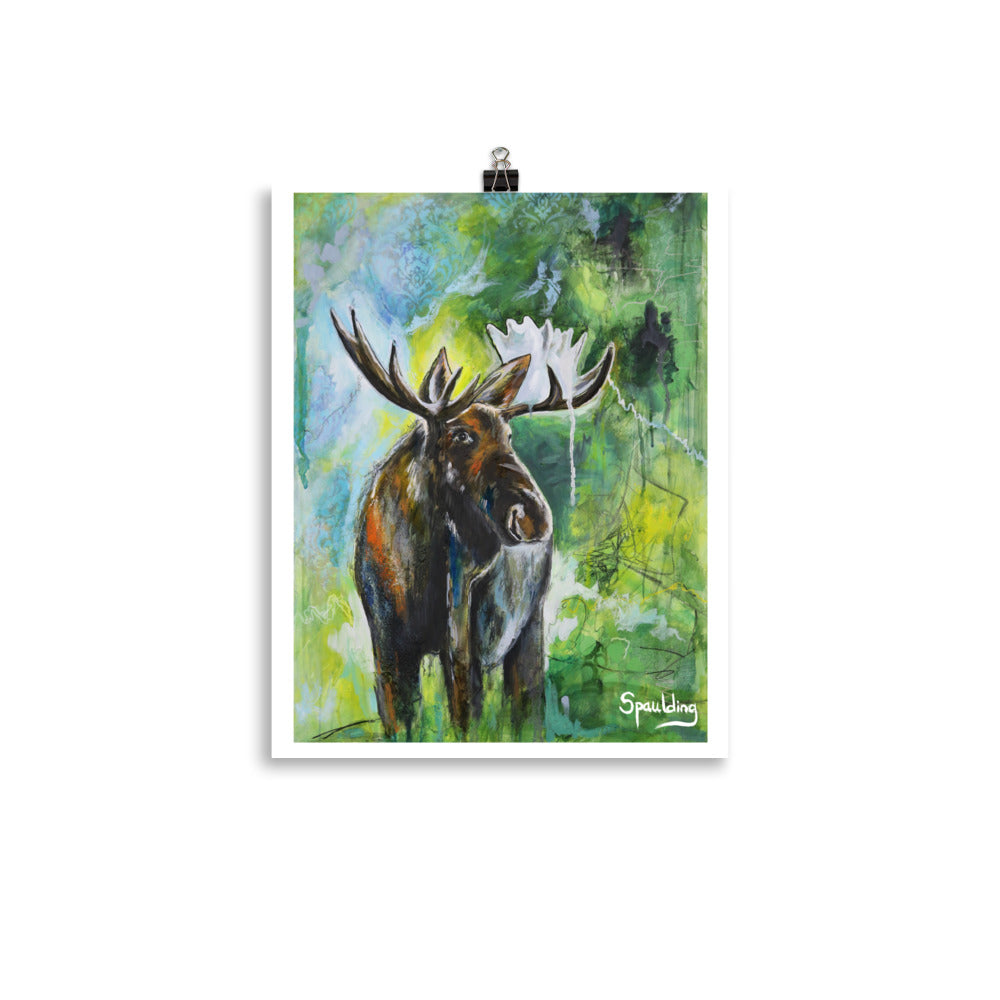 Paper art print of a bull moose with antlers standing in front of a background of, blues, greens and yellow.