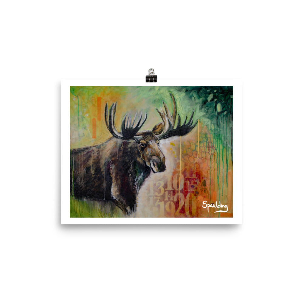 Paper art print of a bull moose with antlers in front of a background of yellows,oranges, reds and green.