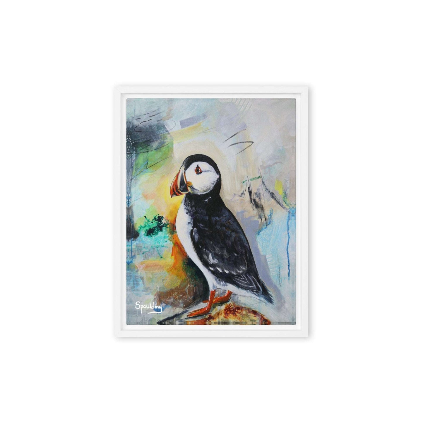 Framed canvas print of a black and white puffin with orange beak and feet standing on a rock. The background is a color palette of light tans, yellows, blues, greens and some black. 