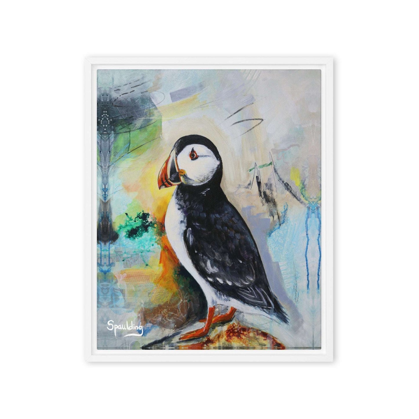 Framed canvas print of a black and white puffin with orange beak and feet standing on a rock. The background is a color palette of light tans, yellows, blues, greens and some black. 