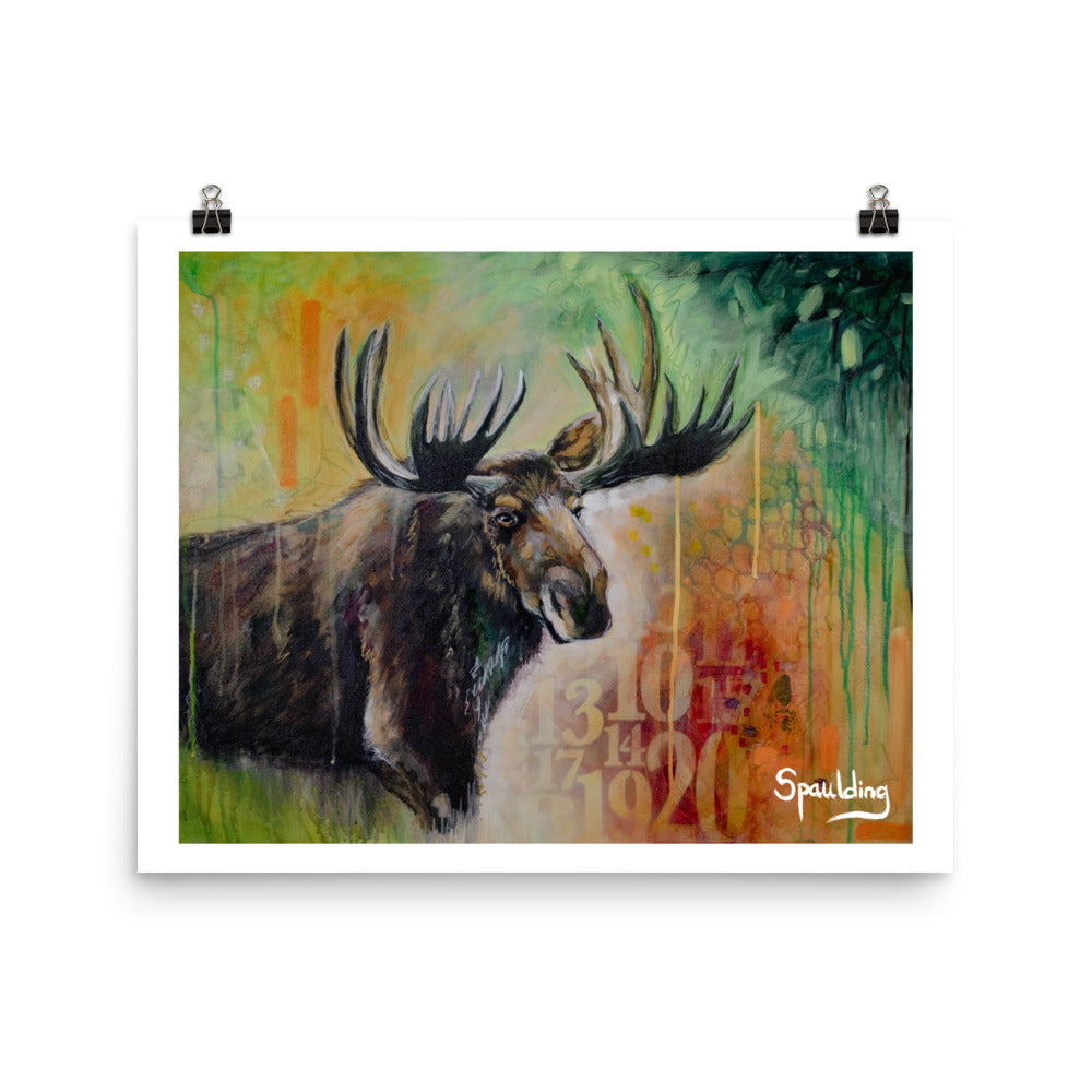 Paper art print of a bull moose with antlers in front of a background of yellows,oranges, reds and green.