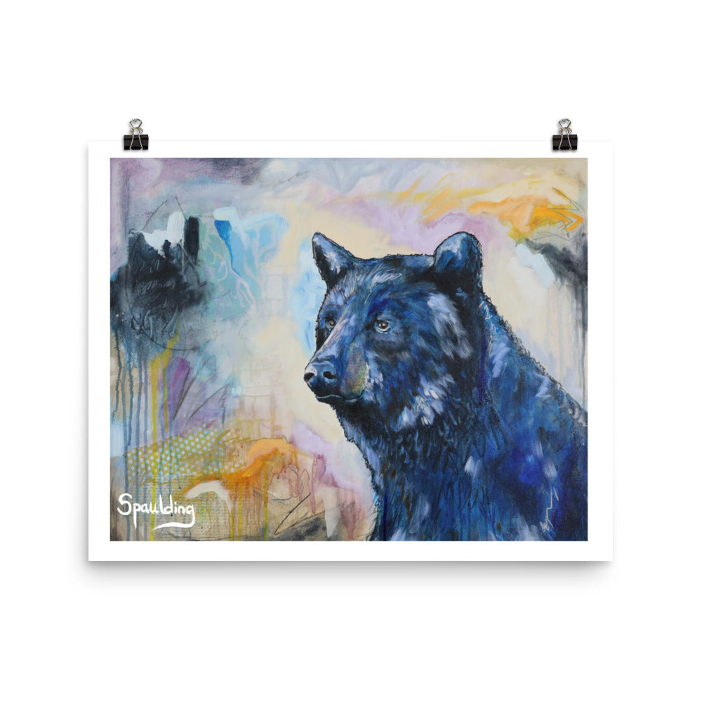 Paper art print of a black bear with a background of tan, orange, blues and black.