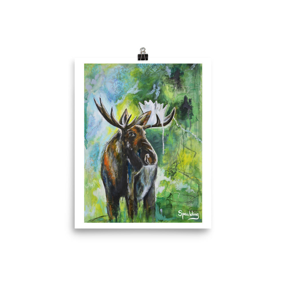 Paper art print of a bull moose with antlers standing in front of a background of, blues, greens and yellow.